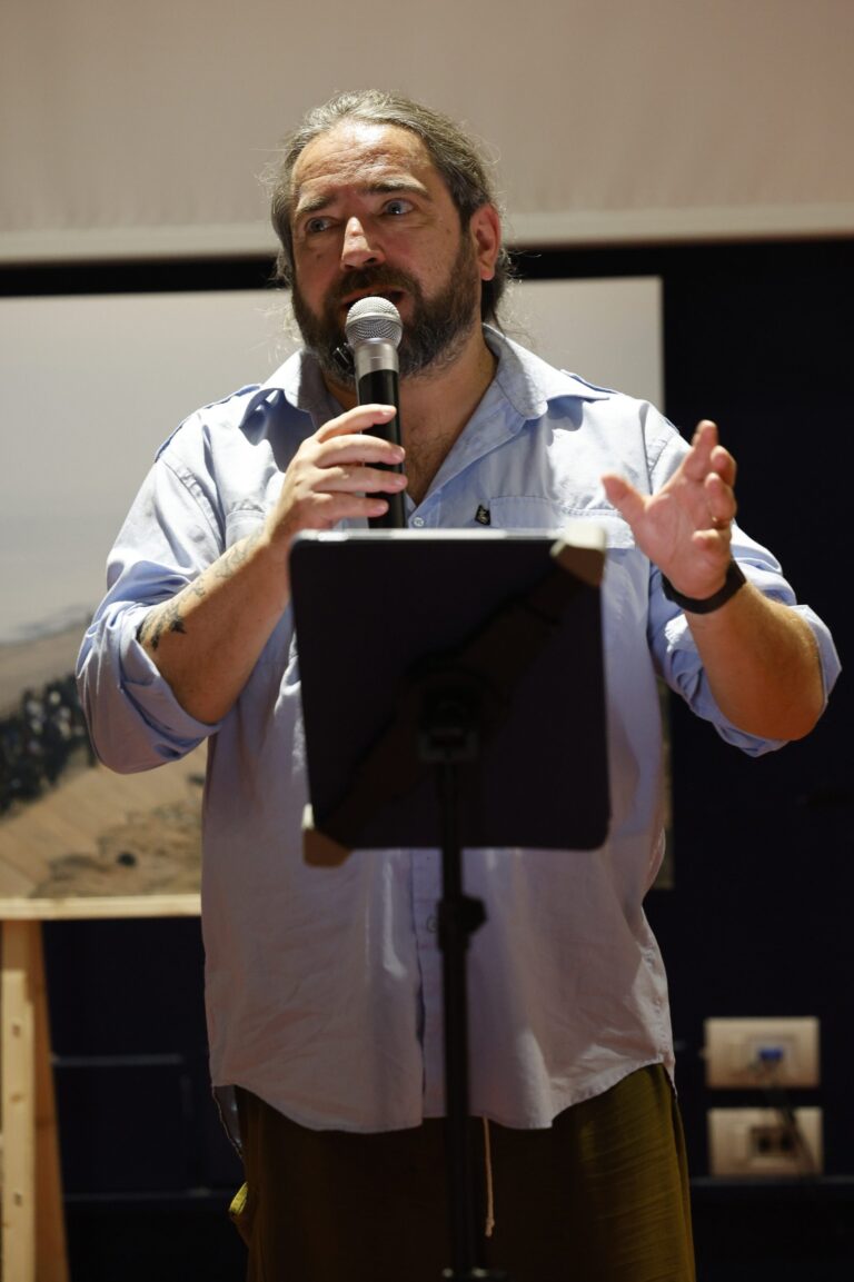 Giulio Cavalli parla al microfono davanti al leggio